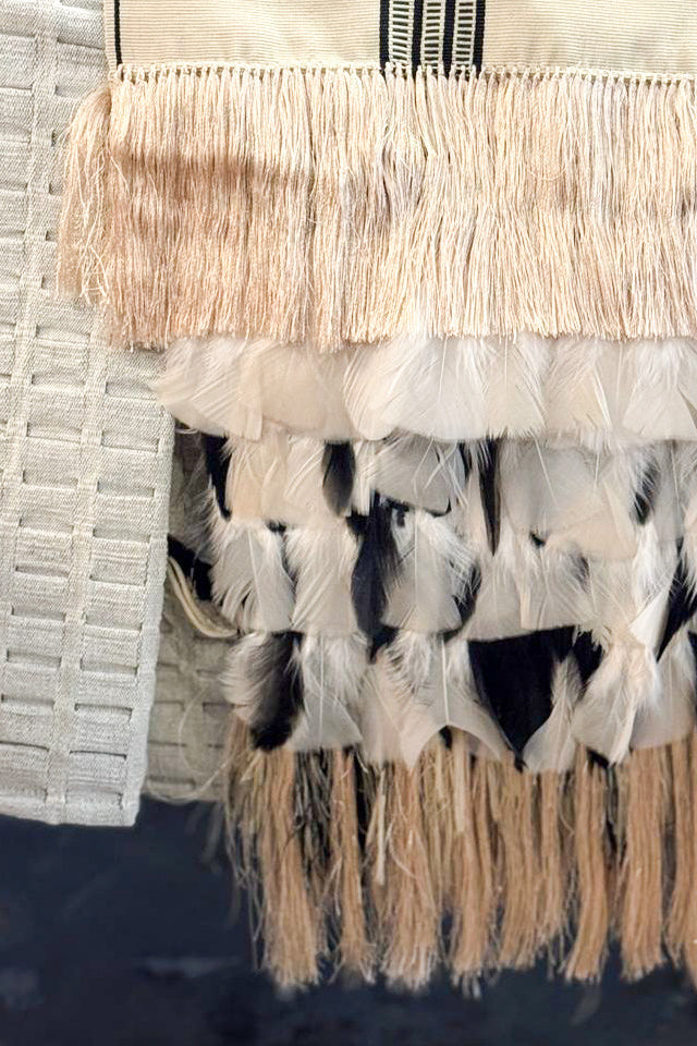 Embajada Craft feather rebozo in ivory, charcoal, and camel colors, showcasing lightweight, woven wearable accessory.