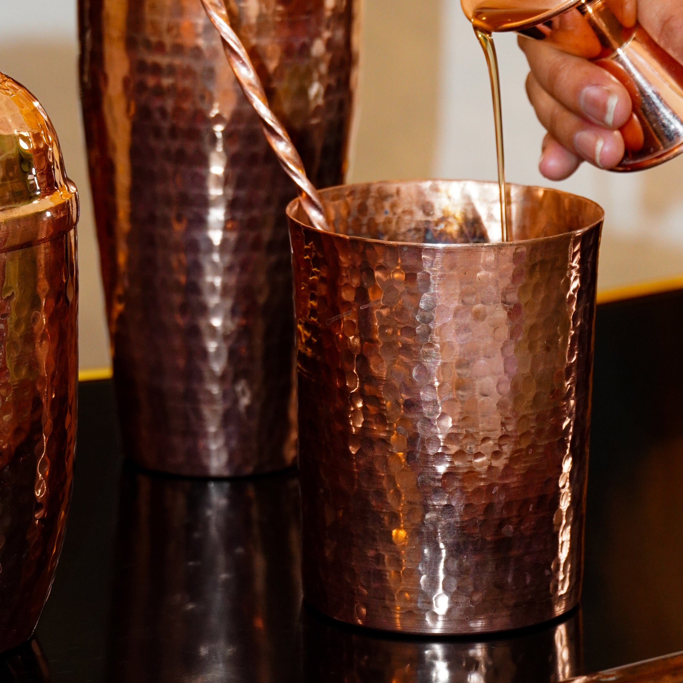 Copper mixing glass with a jigger inside, designed for home decor and cocktail preparation by Oax-i-fornia.