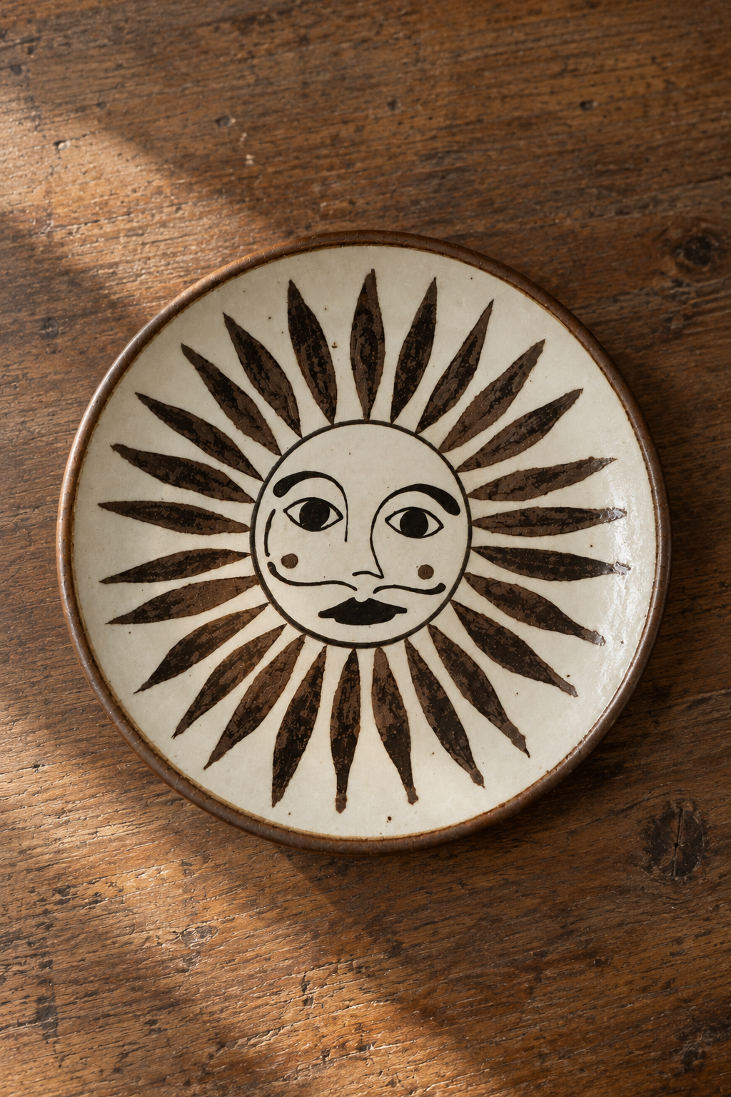 Rustic ceramic dessert plate with sun face design from El Palomar SOL by Oax-i-fornia, featuring vibrant earthy tones and handcrafted details.