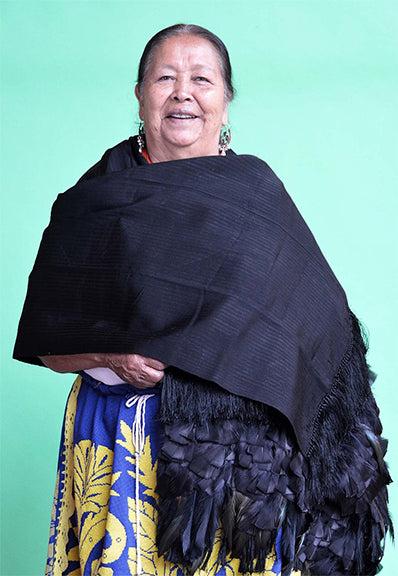 Embajada Craft ivory, charcoal, and camel feather rebozo worn as a stylish wrap or shawl, showcasing soft, lightweight fabric.