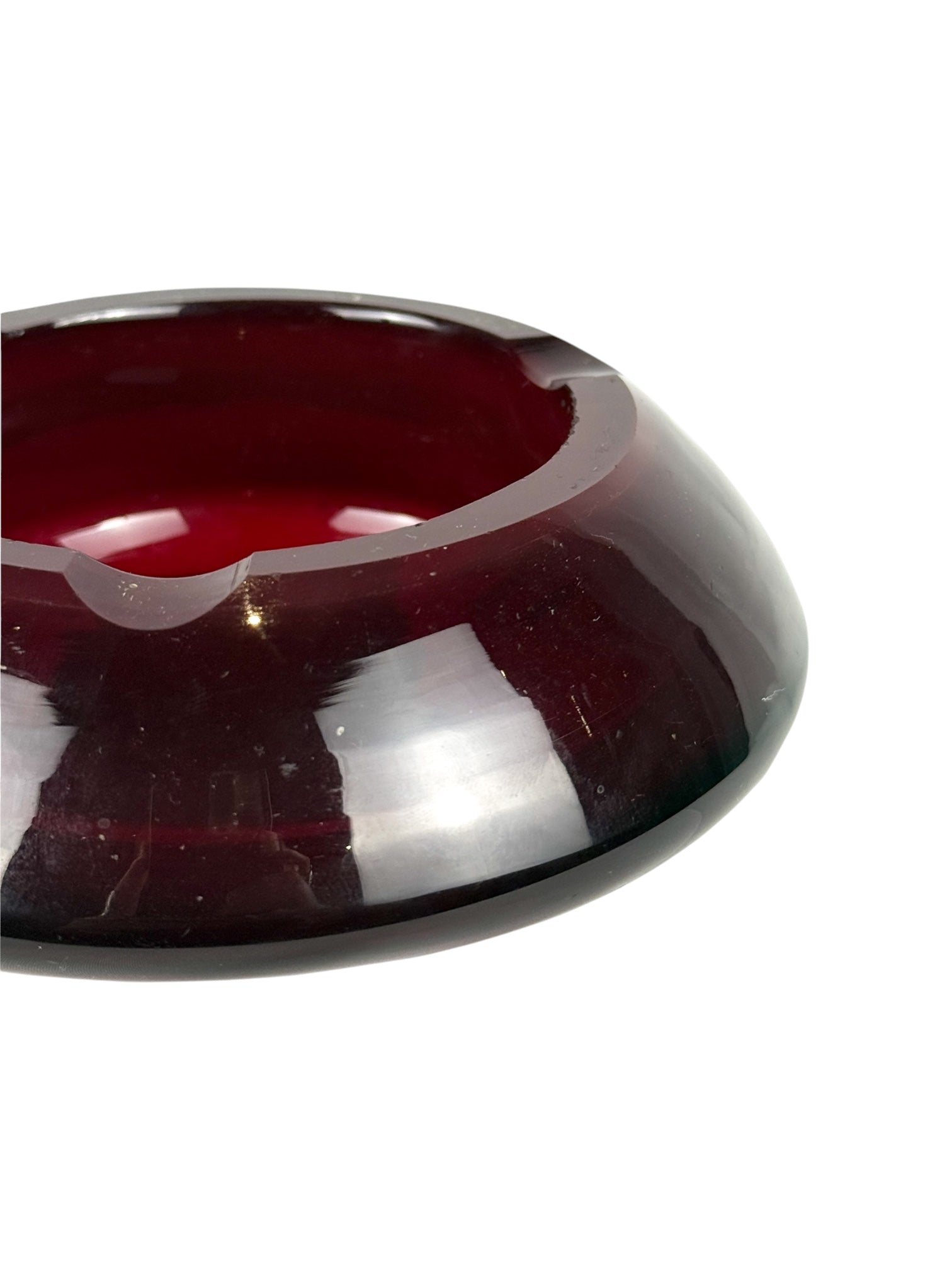Small vintage red pressed glass ashtray from the 1970s, detailed close-up showing its classic shape and vibrant color.