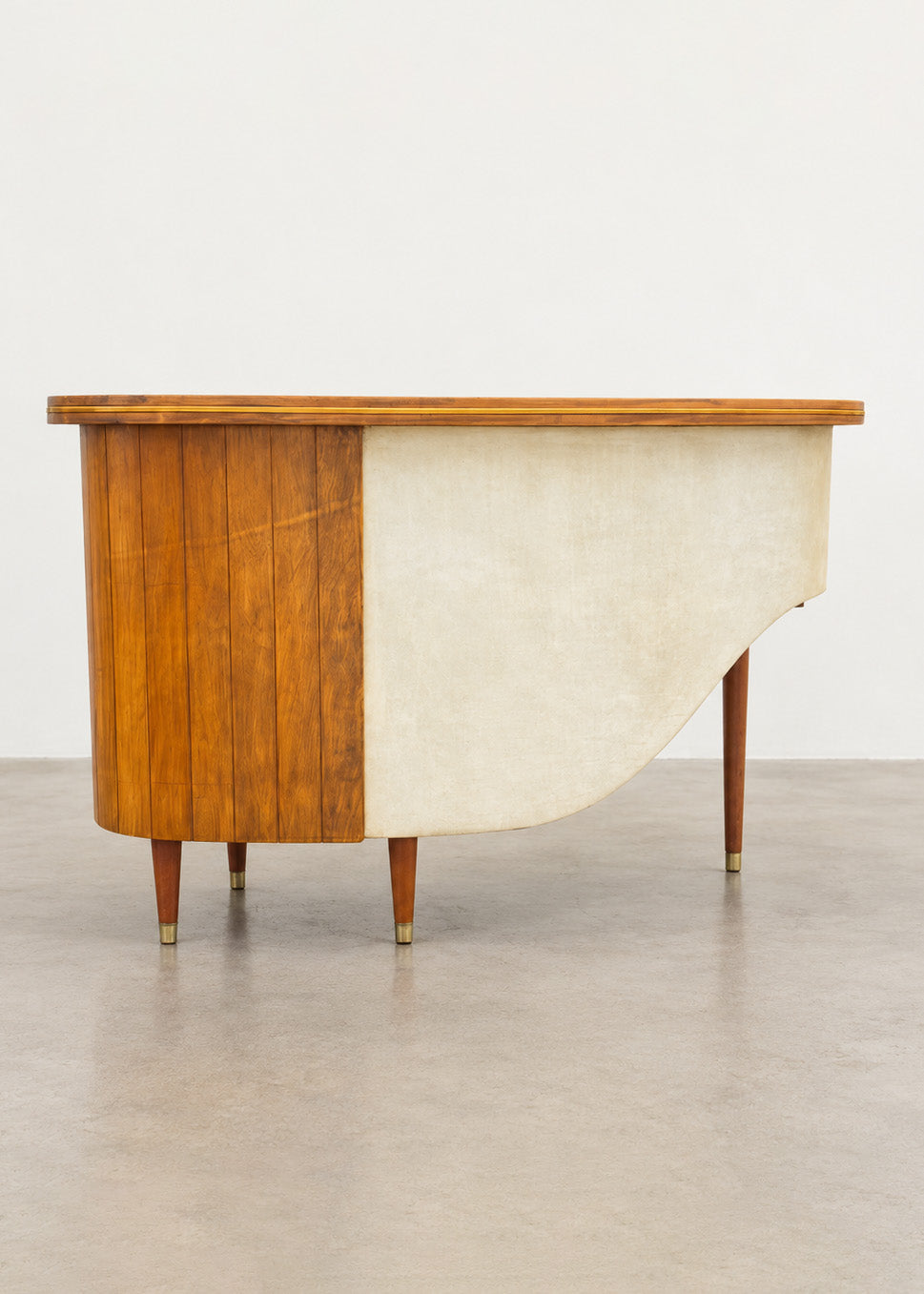 Mid-century sculptural cocktail bar with curved wooden fronts and brass accents, vintage furniture from the 1950s–60s.
