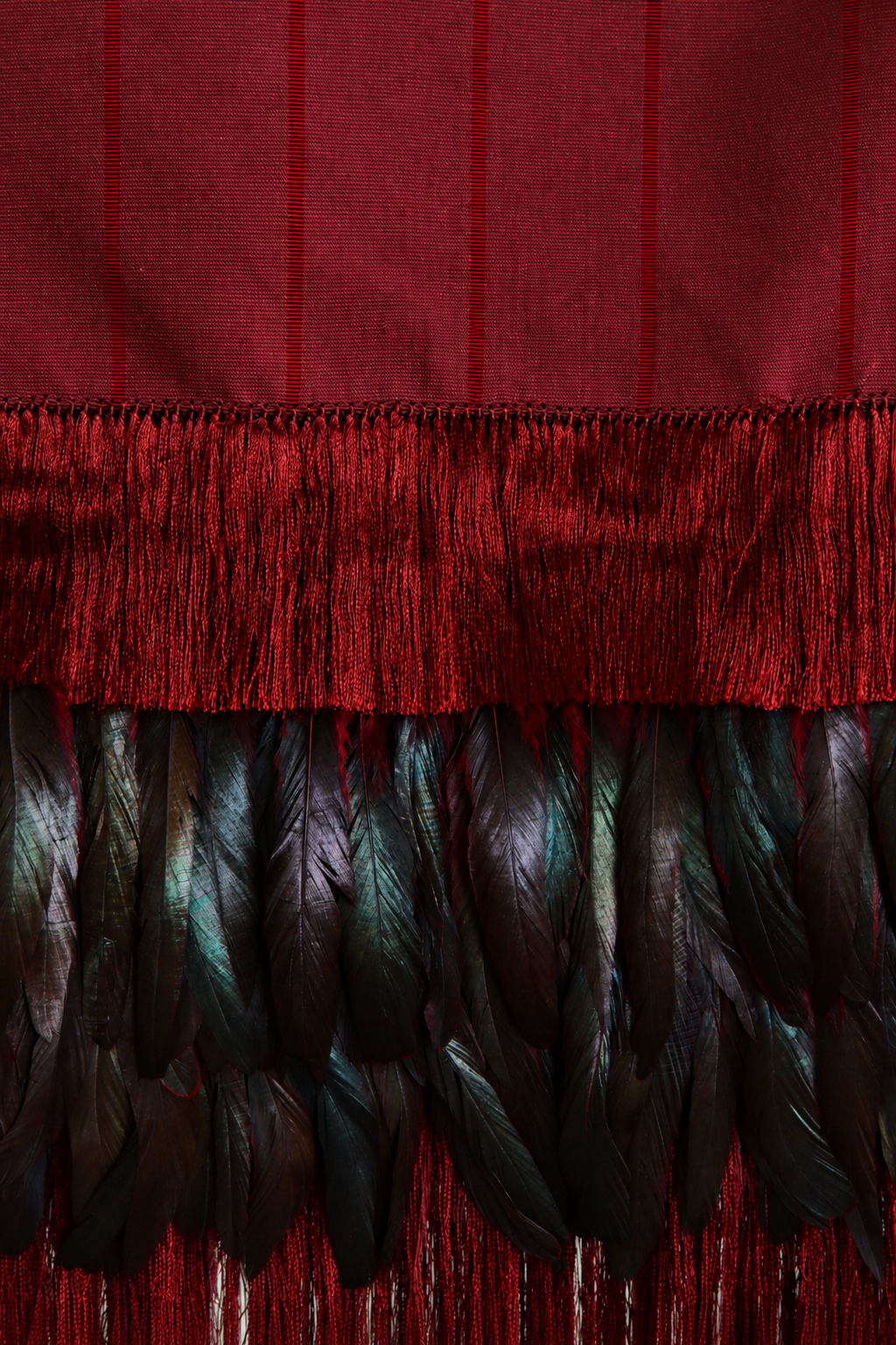 Crimson feather rebozo with black fringe and iridescent feather trim, wearable accessory by Embajada Craft.