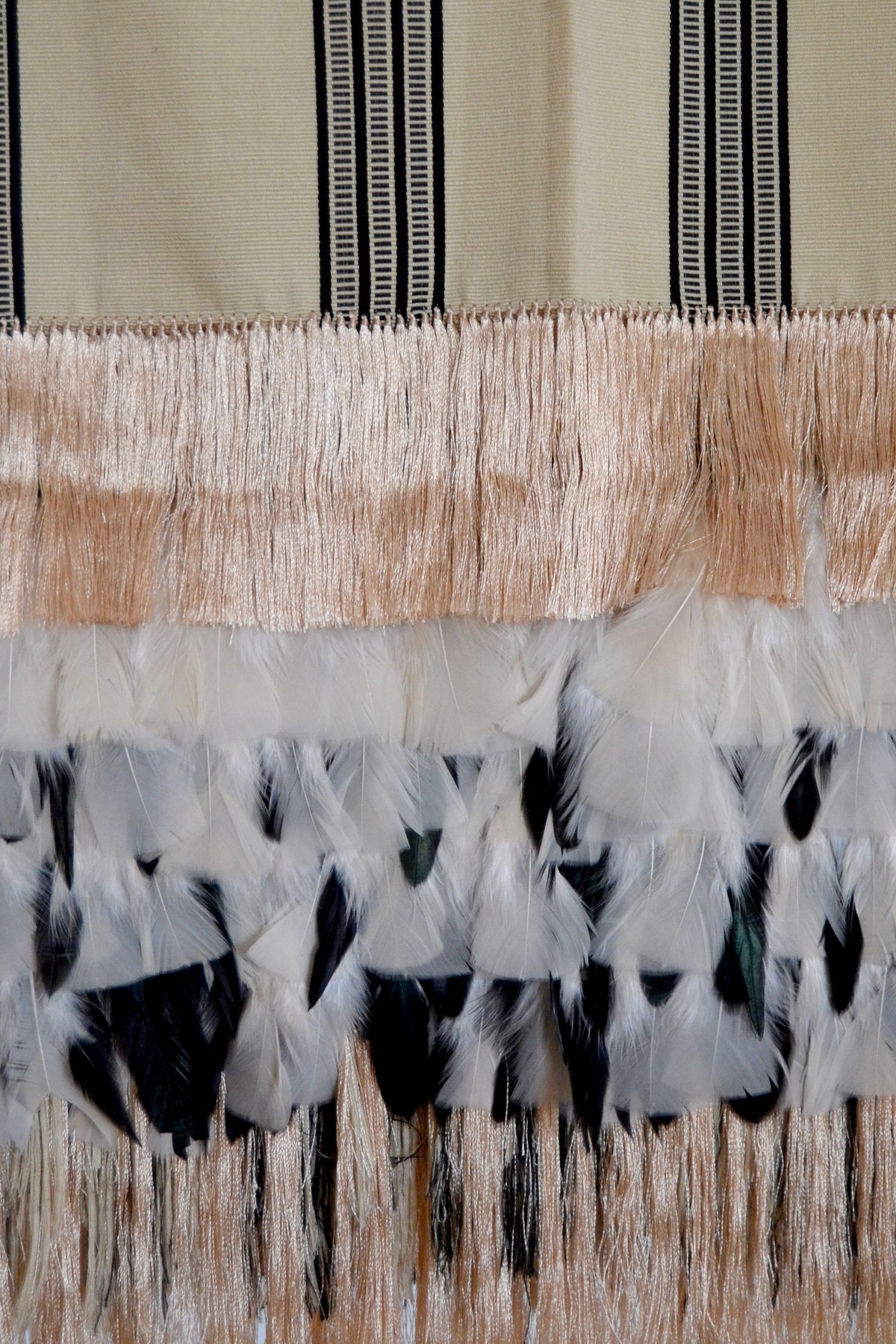 Embajada Craft ivory feather rebozo with charcoal and camel accents, showcasing its lightweight, elegant woven wearables.