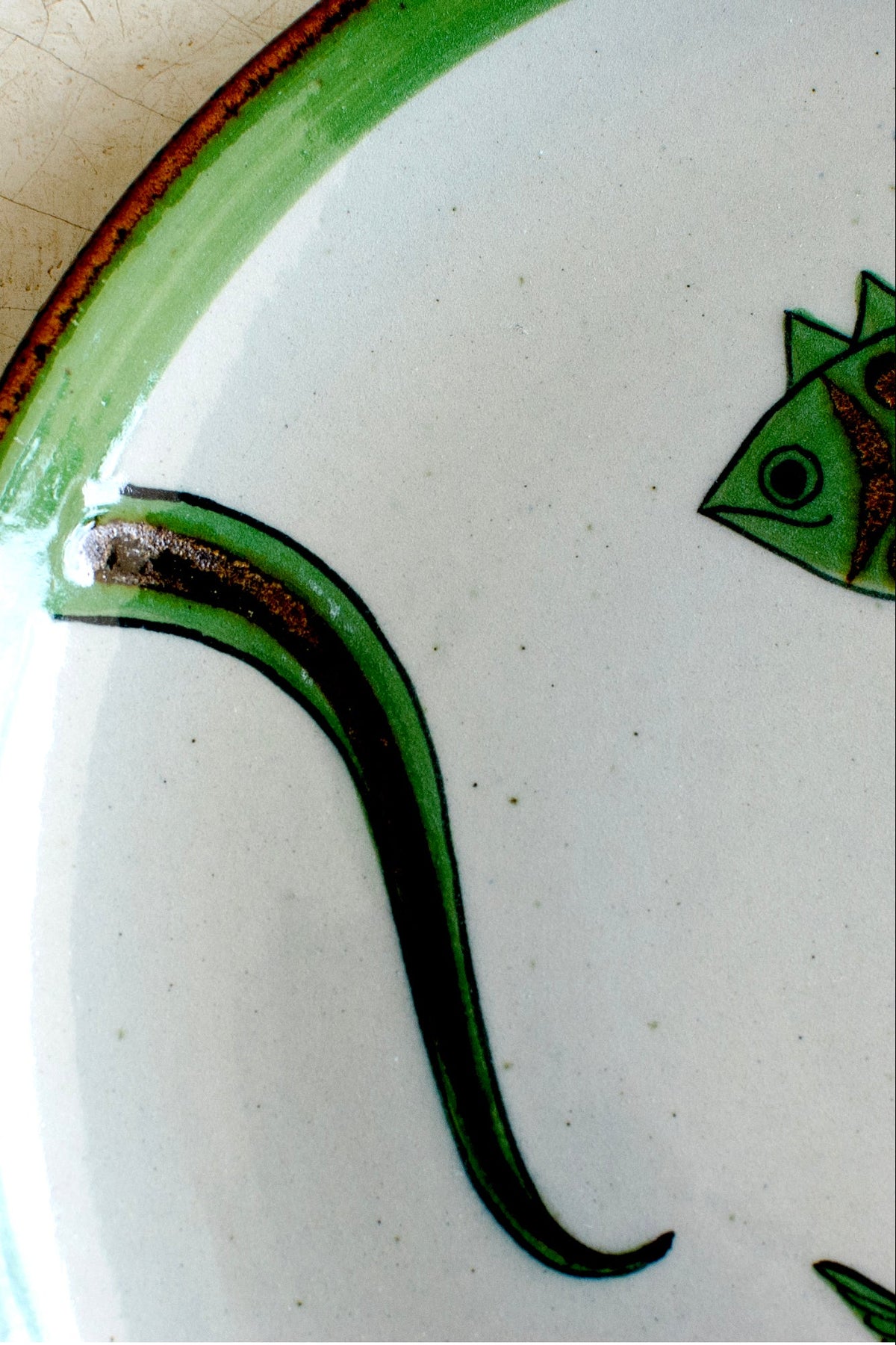 Embajada Craft El Palomar Fish Plate, vibrant ceramic tableware featuring a detailed fish design on a green background.