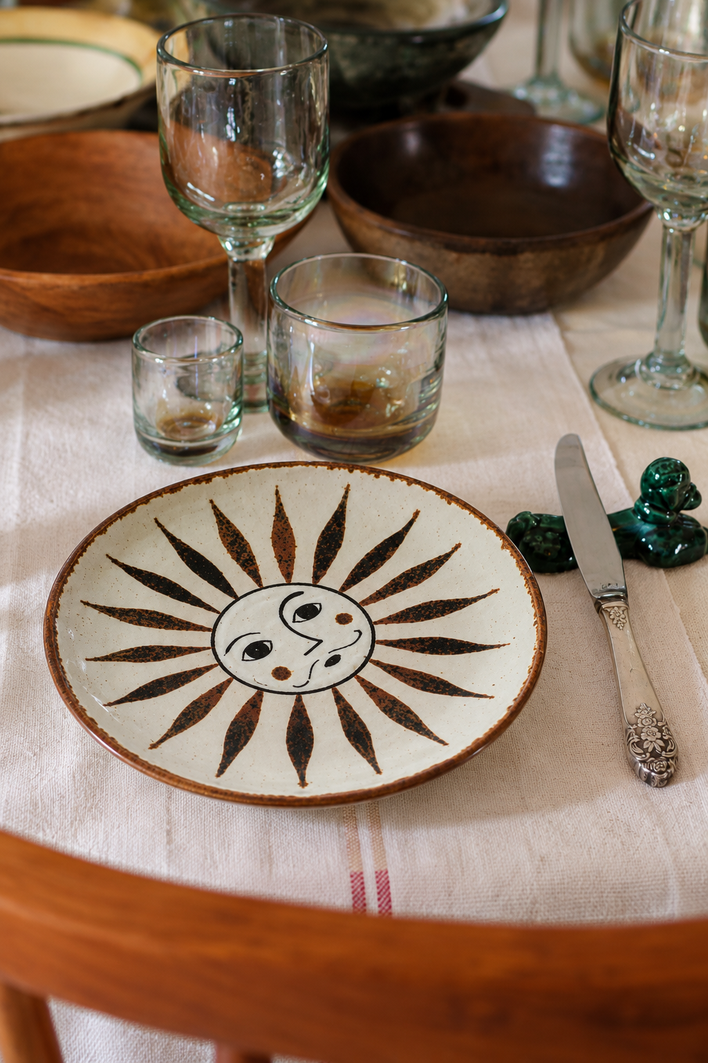 Oax-i-fornia El Palomar SOL dessert plate with rustic sun-face design, part of a stylish tableware setting.